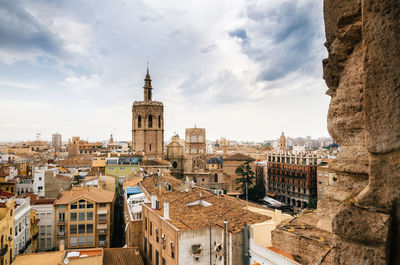 Buildings in town against cloudy sky