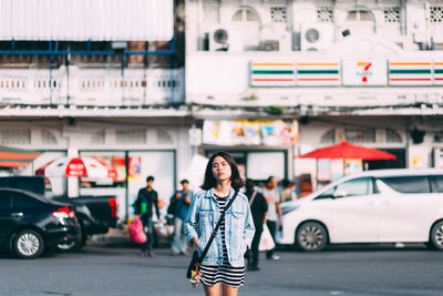 Portrait of woman standing on street in city