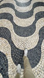 Low section of man standing on tiled floor