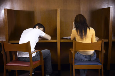 Rear view of two people sitting on chair