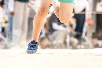 Low section of man running on track