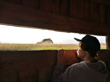 Rear view of teenage boy standing against sky