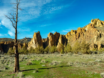 Panoramic view of rocky mountains against blue sky