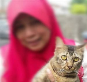 Portrait of smiling young woman with cat