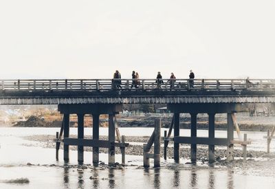 People on beach against clear sky