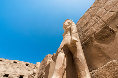 Low angle view of statue against blue sky