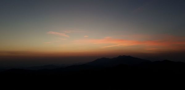 Scenic view of silhouette mountains against sky during sunset