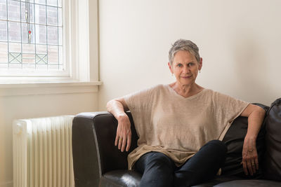 Portrait of smiling man sitting on sofa at home