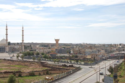 High angle view of railroad tracks by buildings in city against sky