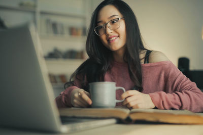 Asian woman smiling witha a laptop