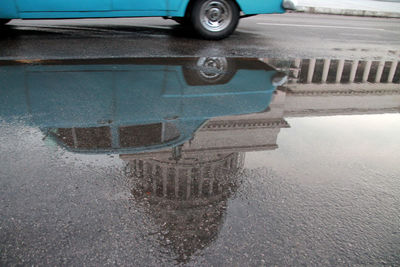 Reflection of car in puddle on road