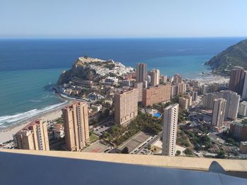 High angle view of city by sea against sky