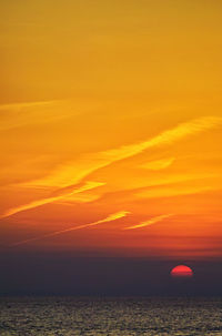 Sunset view of sea against orange sky