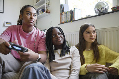 Mother playing video games with two teenage daughters