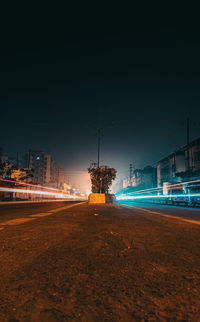 Light trails on road against sky at night