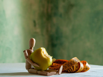 Close-up of apple on table against wall