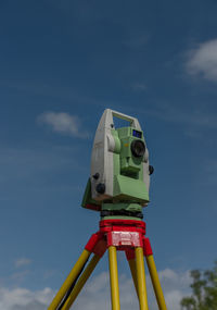 Low angle view of coin-operated binoculars against sky