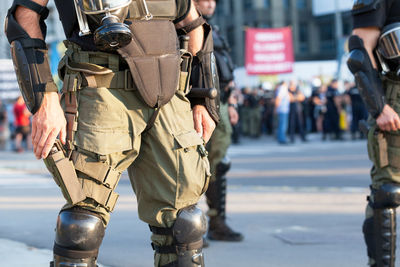 Midsection of army soldiers standing on street