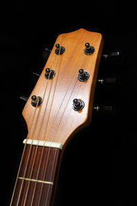 Close-up of guitar against black background