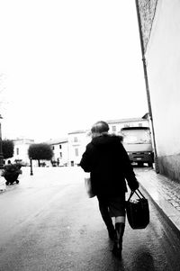 Rear view of woman standing against clear sky