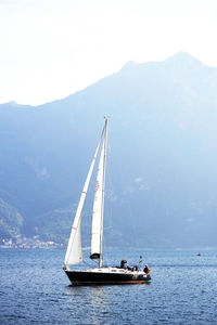 Sailboat sailing on sea against sky