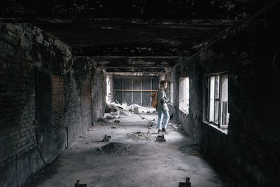 Side view of young man standing in abandoned building