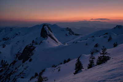 Scenic view of snowcapped mountains against sky during sunset