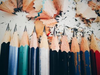 Close-up of multi colored pencils and shavings on table