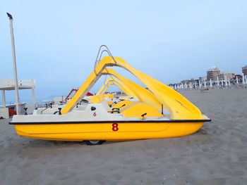 Yellow ship in water against clear sky