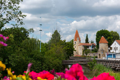 Panoramic view of flowering trees and buildings against sky