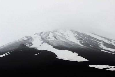 Close-up of snow capped mountain against clear sky