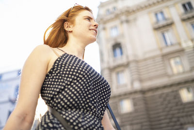 Cheerful lady walking on city street