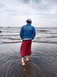 Rear view of man standing on beach