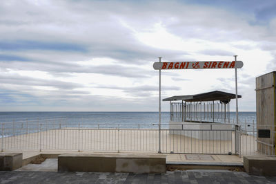 Lifeguard hut on beach against sky