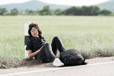 Full length of tired girl sitting on land