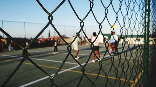 Group of people playing on chainlink fence