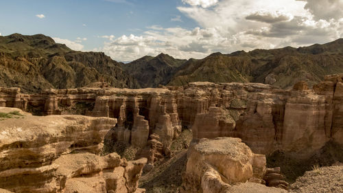 View of rock formations against cloudy sky