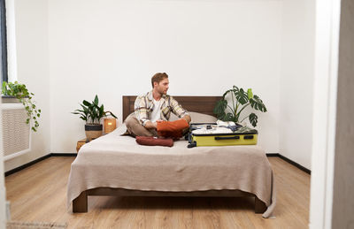 Portrait of woman sitting on bed at home