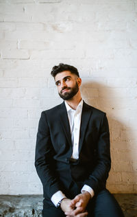 Portrait of businessman standing against wall