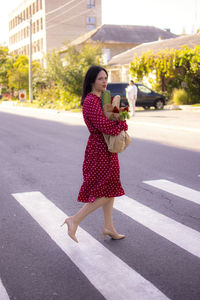 Full length of young woman standing on road