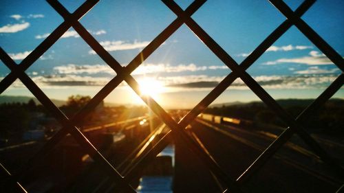 Scenic view of sunset seen through chainlink fence