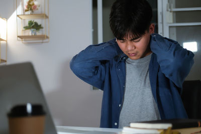 Man using mobile phone while sitting on table