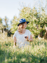 Young woman using smart phone on field