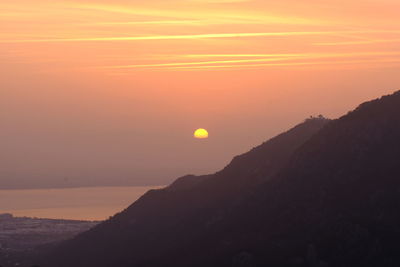 Scenic view of silhouette mountains against romantic sky at sunset