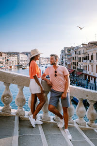 Men standing on bridge in city against sky