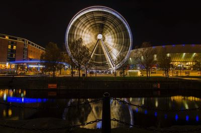 Illuminated ferris wheel at night