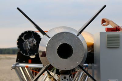 Close-up of person holding airplane against sky