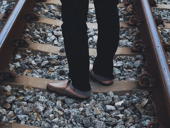 Low section of person standing on railroad track