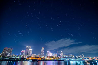 Illuminated buildings in city against sky at night