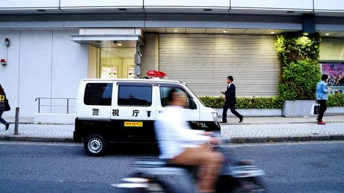 Blurred motion of people on road in city